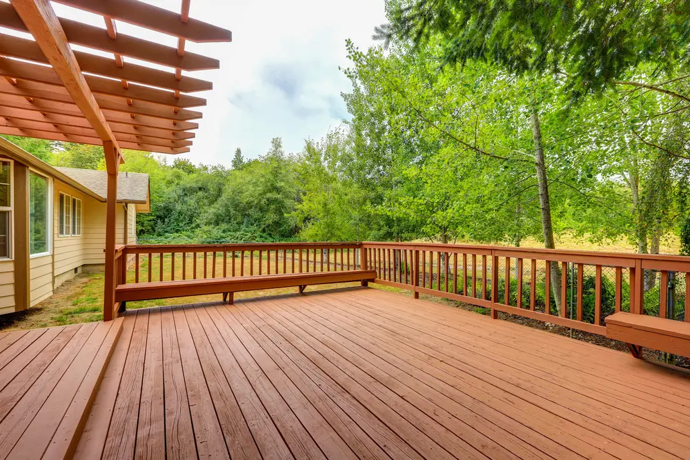 Spacious wood deck with built-in seating and pergola, ideal for summer-ready backyard gatherings in Roselle.