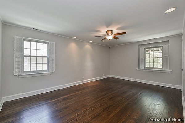 A room with hardwood floors and ceiling fans.