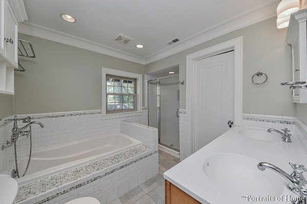 A bathroom with a tub, toilet and shower.