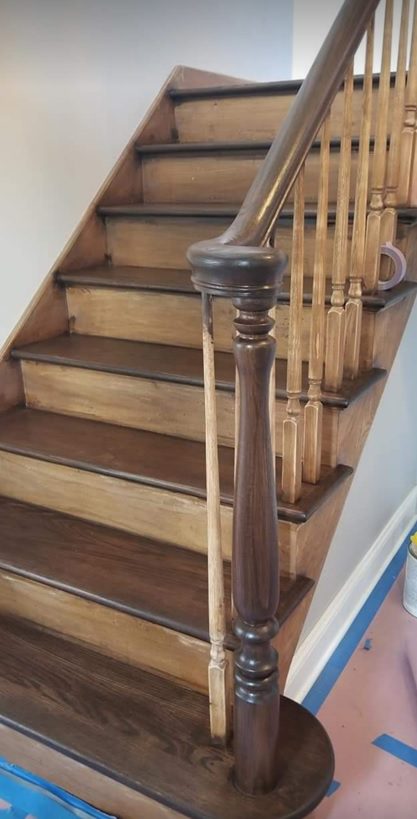 A wooden staircase with wood railing and handrail.