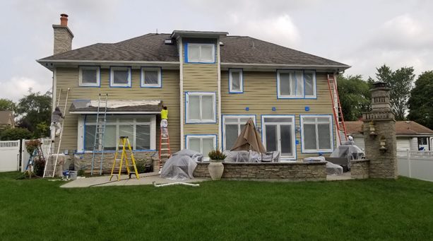 A house with some windows and doors being painted