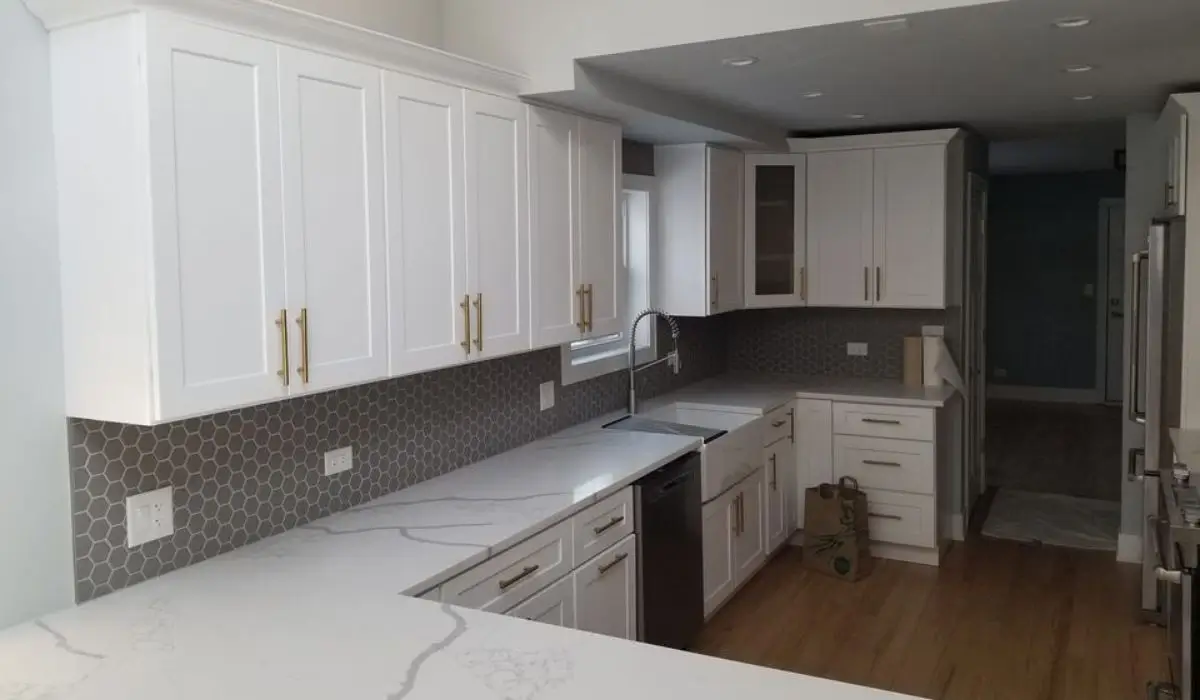 Modern kitchen with fresh white cabinet painting, sleek countertops, and stylish gray backsplash for a contemporary look.