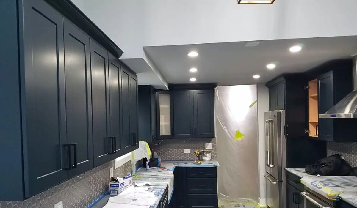 Kitchen cabinets covered and prepped for professional cabinet repaint, offering homeowners an affordable alternative to replacement.