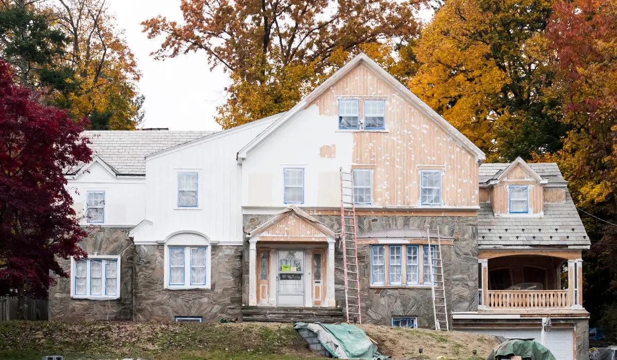 Paint Before Fall and Winter in Glen Ellyn showing home exterior under preparation, siding repairs, and painting work with ladders set up.