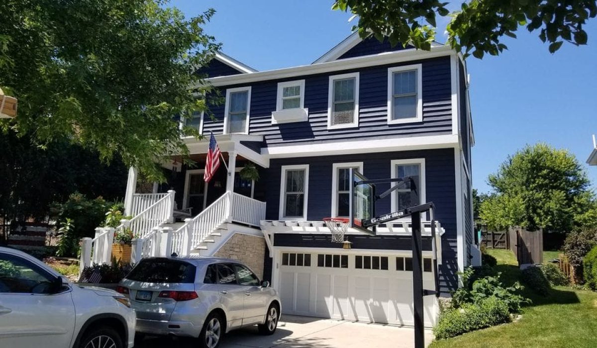 quality-home-exterior-paint Two-story home with fresh navy exterior paint and white trim that resists peeling under harsh weather.